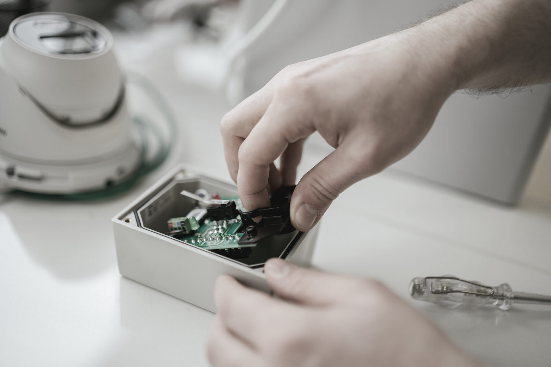 Detailarbeit an einer Platine neben einer Kamerakuppel