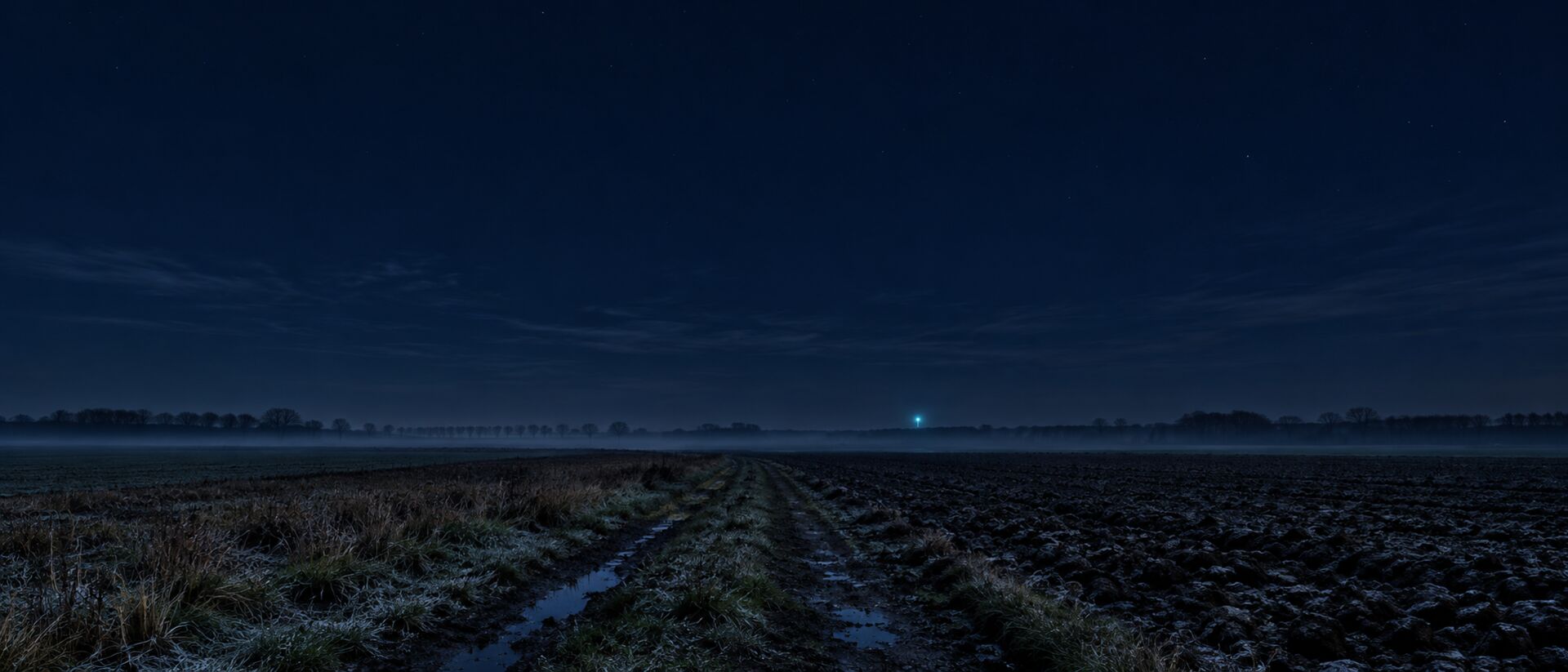 Offene Feldflur bei Nacht, ein Feldweg führt zum Horizont, Bodennebel